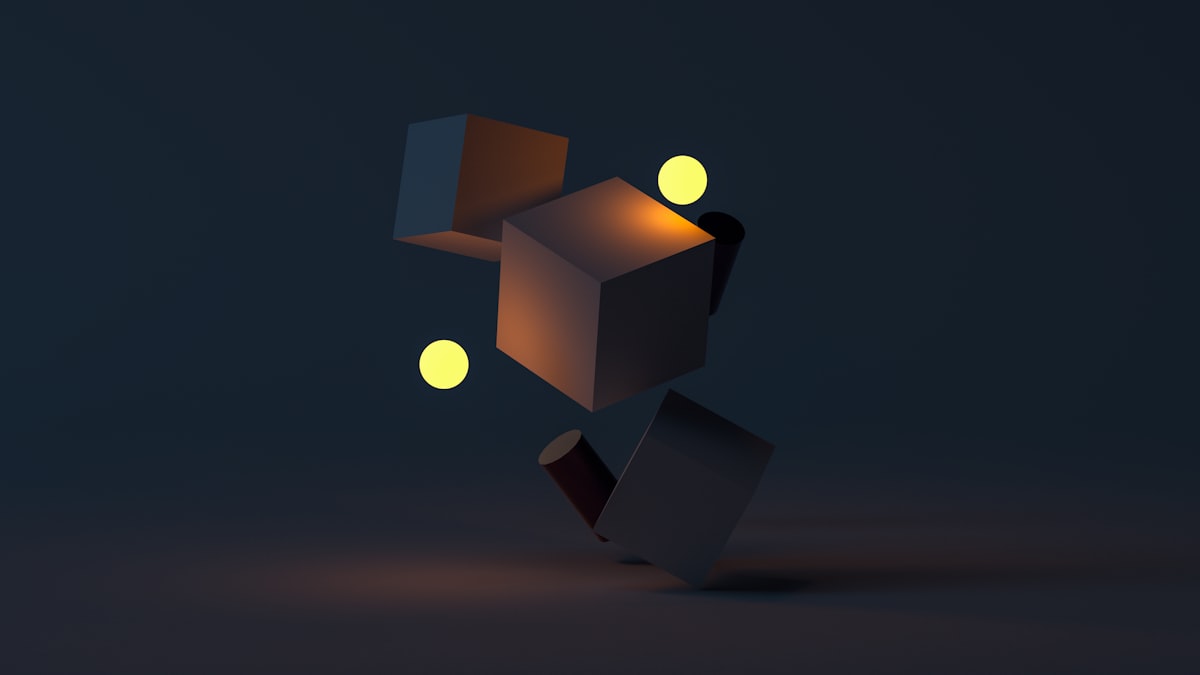 Floating 3D cubes and spheres lit against a dark background